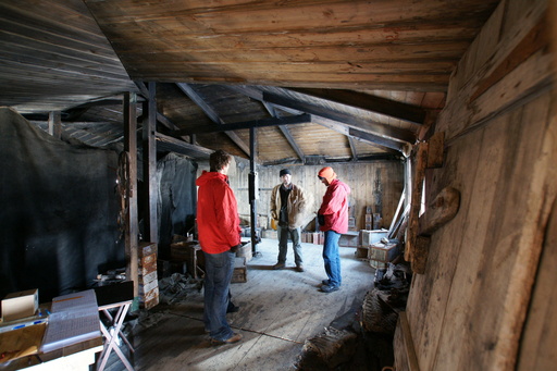 Inside Discovery Hut, a volunteer guide explains the history of the hut to Campbell and Luke. (click to enlarge)