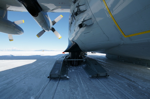 These are ski-equipped Hercules aircraft: they can land on wheel or skis depending on the position of the hydraulically operated skis. Also visible (directly above and to the right of the wheel) are the attachment points for the JATO (Jet Assisted Take Off) bottles - which are solid-rocket boosters that give the aircraft an additional kick when trying to take off from high-altitude sites with lots of cargo. (click to enlarge)
