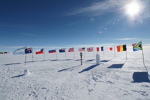 The Ceremonial Pole, with the flags of the founding members of the Antarctic Treaty, the \'barber pole\' topped with a shiny metallic sphere, and an ice bust of Roald Amundsen which was unveiled by the Norwegian Prime Minister last week. (click to enlarge)