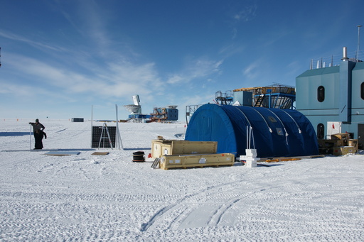 Campbell and Luke assembling solar panels (the black square) with our Polar Haven tent to the right, and the 10 metre South Pole Telescope in the background. (click to enlarge)