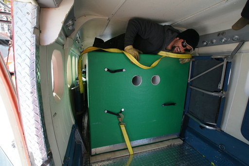 Our pilot, Gary, climbing out over the 350kg Engine Module after having loaded it into the Twin Otter. (click to enlarge)