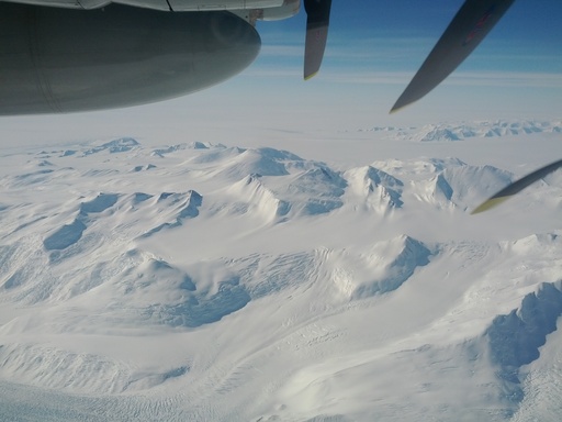 A typical view during the first hour of the flight to the South Pole. A glacier winds its way over a mountain pass to lower altitudes, forming a treacherous crevasse field at bottom left. CREDIT: Luke Bycroft. (click to enlarge)